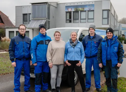 Mitarbeiter des Kundendienst-Teams von Fischer vor einem Transporter und dem Firmengebäude.